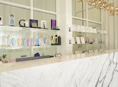Mostrador de recepción en Doctor Tony Clinic con exhibición de premios y certificados