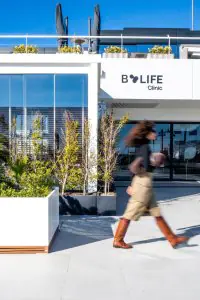 الواجهة الحديثة لعيادة B-Life مع واجهة زجاجية ونباتات خضراء