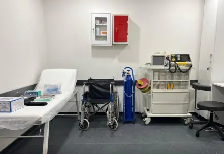 Sala de tratamiento médico en Este Favor Hair Transplant Clinic con silla de ruedas y equipo