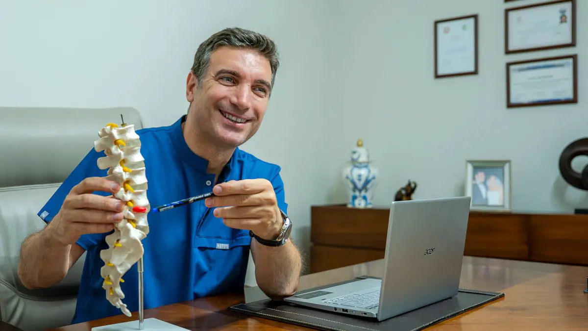 Consultation room at Uzm. Dr. Enis Biçerer Clinic with spine model and doctor