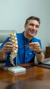 طبيب في عيادة Uzm. Dr. Enis Biçerer يشرح نموذج العمود الفقري بغرفة الاستشارة