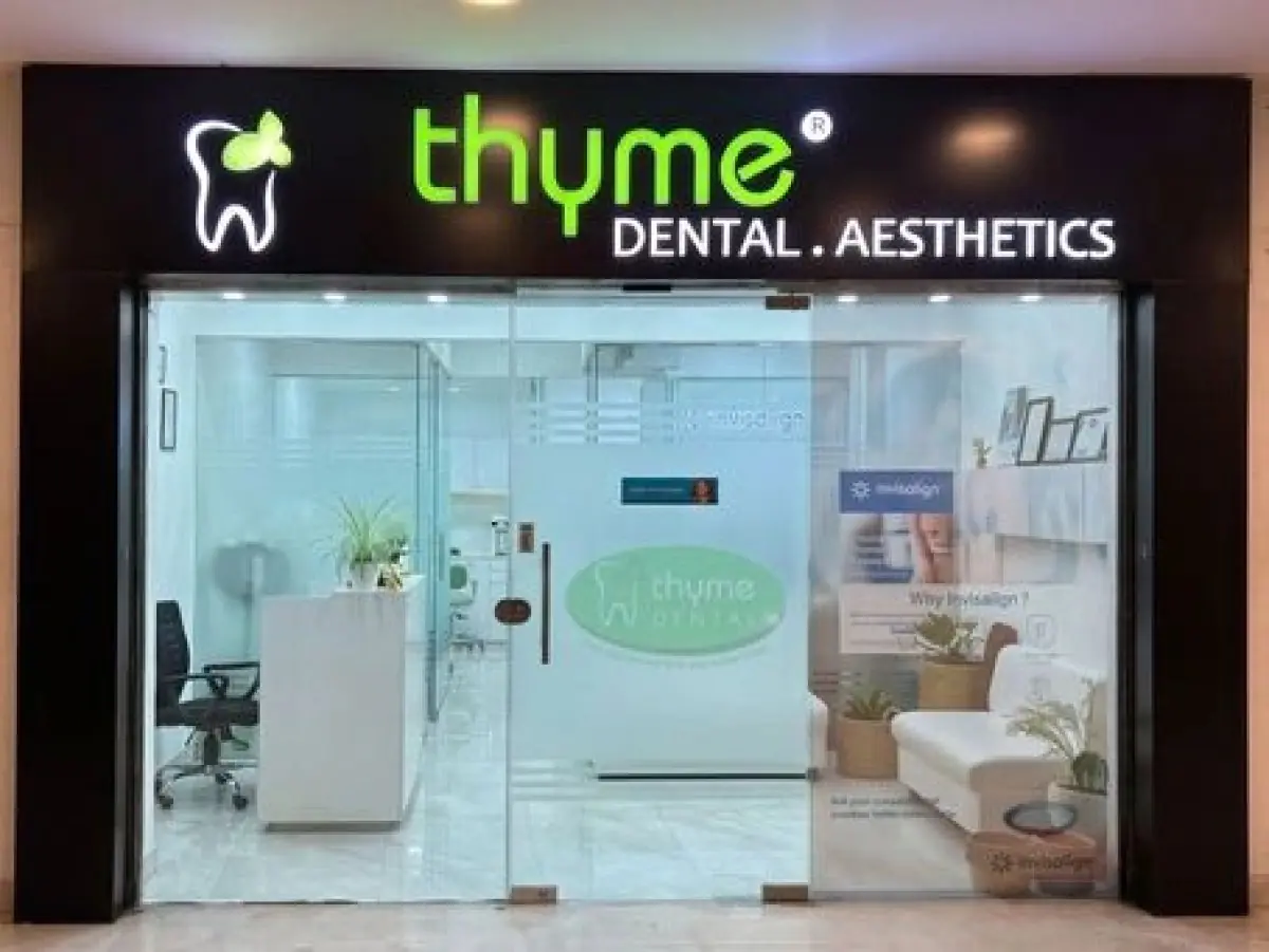 Eingang der Thyme Dental Klinik mit moderner Glasfassade und Empfangsbereich
