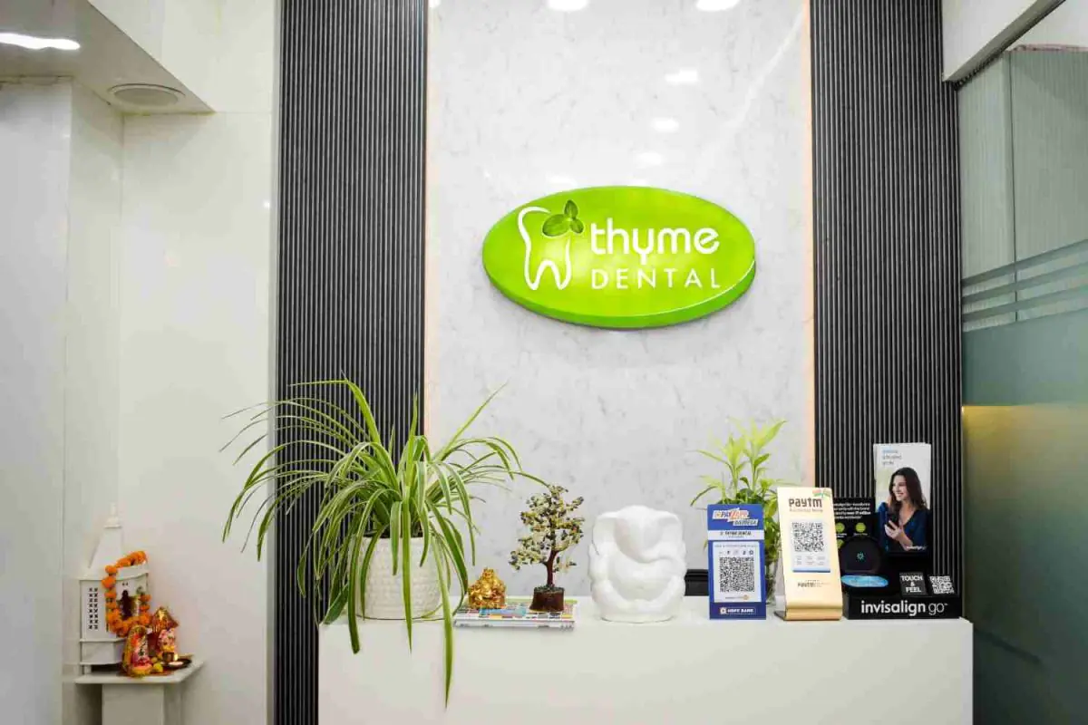 Empfangstresen der Thyme Dental Klinik mit modernem Dekor und grünem Schild
