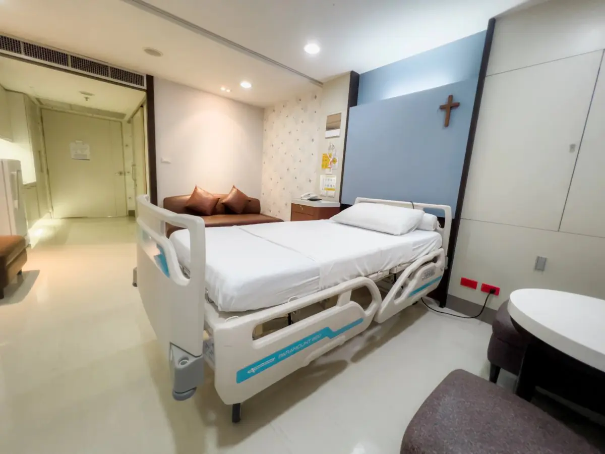 Палата пацієнта в Bangkok Christian Hospital із сучасним ліжком і диваном