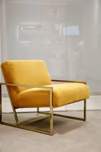 Sillón amarillo moderno en la sala de espera de NOVA Dental Institute