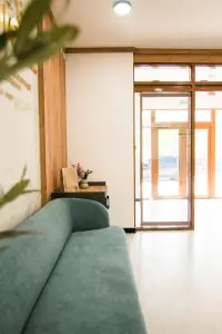 Área de espera con sofá moderno en la clínica Rea:Medical