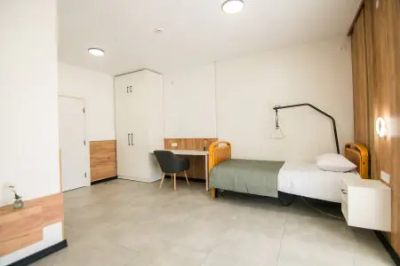 Habitación de paciente en la clínica Rea:Medical con cama moderna y comodidades