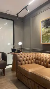 منطقة انتظار في Roger Domingos Medical Services Ltda. مع أريكة جلدية وديكور عصري