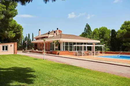 Exterior de la clínica ZEUS Centro Terapéutico con jardín y piscina al aire libre