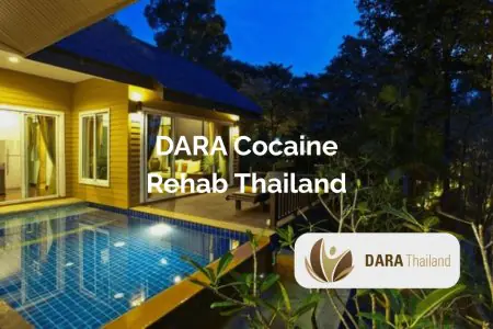 الواجهة الخارجية لعيادة DARA Rehab Thailand مع مسبح وحديقة عند الغروب
