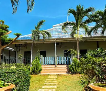 Exterior de la clínica SafeHouse Rehab Thailand con jardín tropical y palmeras