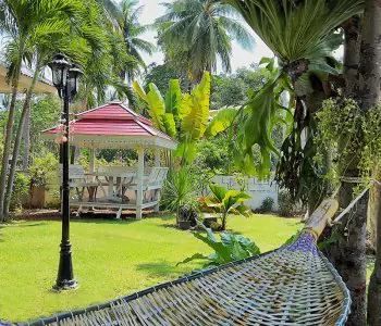 Jardín tropical con cenador y hamaca en SafeHouse Rehab Tailandia