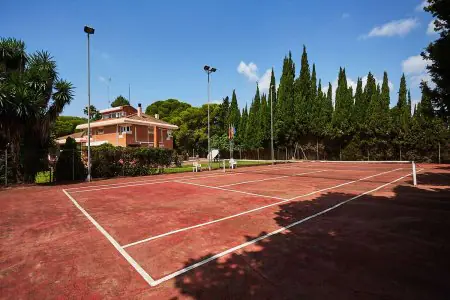 Pista de tenis exterior en ZEUS Centro Terapéutico rodeada de vegetación