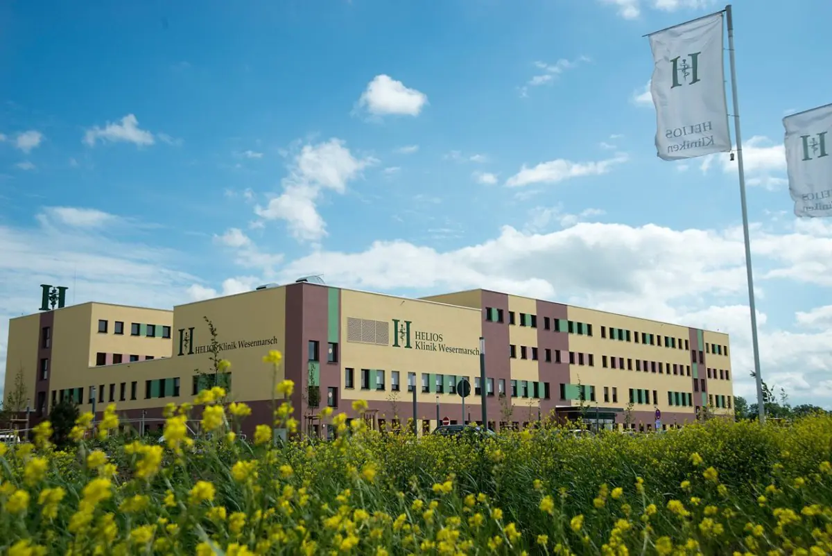 Внешний вид Helios Klinik Wesermarsch в Германии, современное здание и флаги