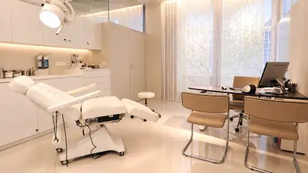 Sala de consulta y tratamiento moderna en la clínica JUVENIS con sillón médico y escritorio