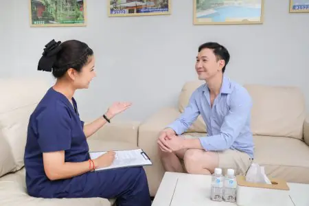 غرفة استشارة في Phufa Resthome مع موظف ومريض على أرائك بيج