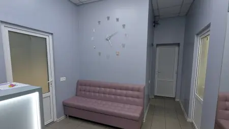 Sala de espera en Synergy Dental Clinic con sofá moderno y reloj de pared en forma de diente