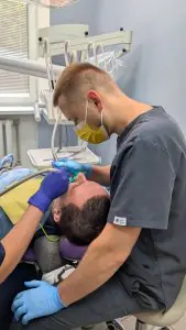 Dentista realizando procedimiento dental en sala de Synergy Dental Clinic
