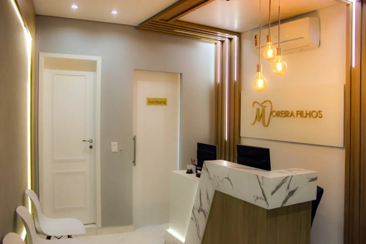 Reception area at Moreira Filhos Clinic with modern marble desk and seating