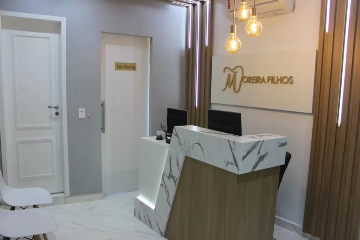 Reception area at Moreira Filhos clinic with modern marble desk and seating