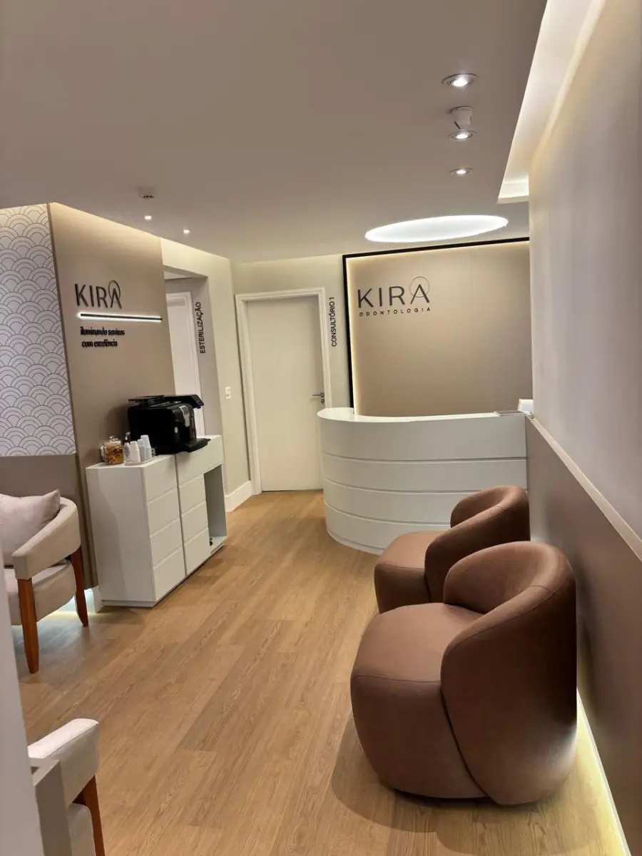 Reception area at Kira Odontologia clinic with modern seating and coffee station