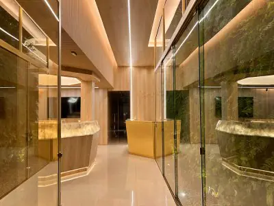 Área de recepción en Kira Odontologia con diseño moderno de madera y vidrio