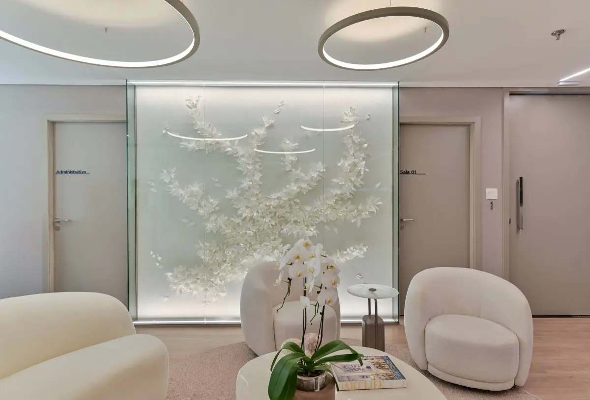 Modern clinic waiting area with white chairs and floral wall decor