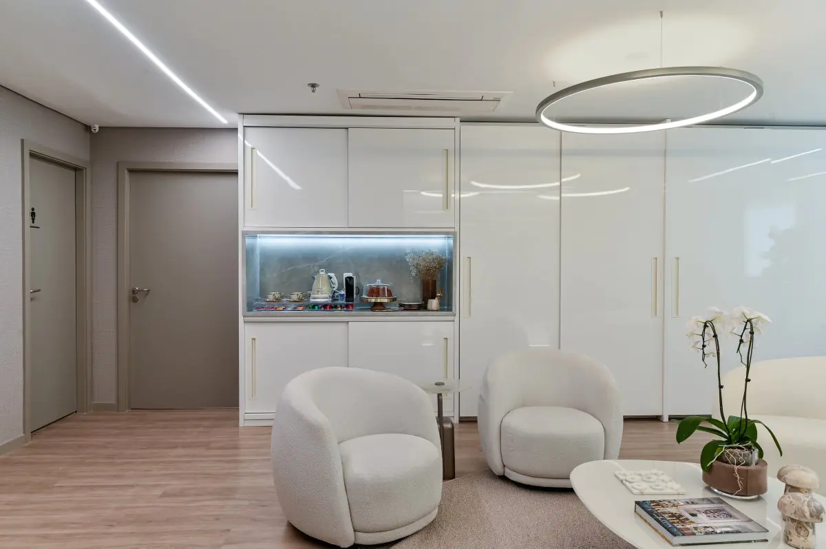 Modern clinic waiting area with white chairs and refreshment counter