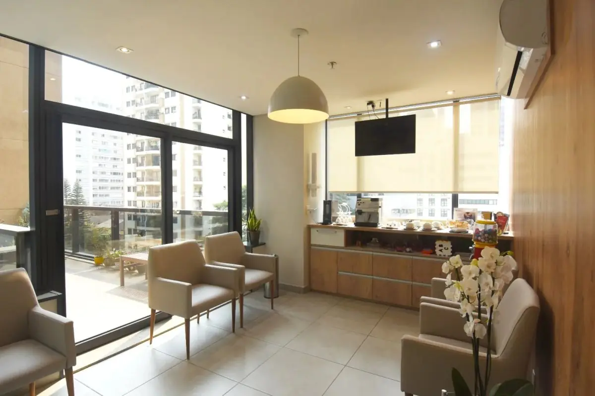 Waiting room at Portal do Sorriso clinic with modern seating and city view