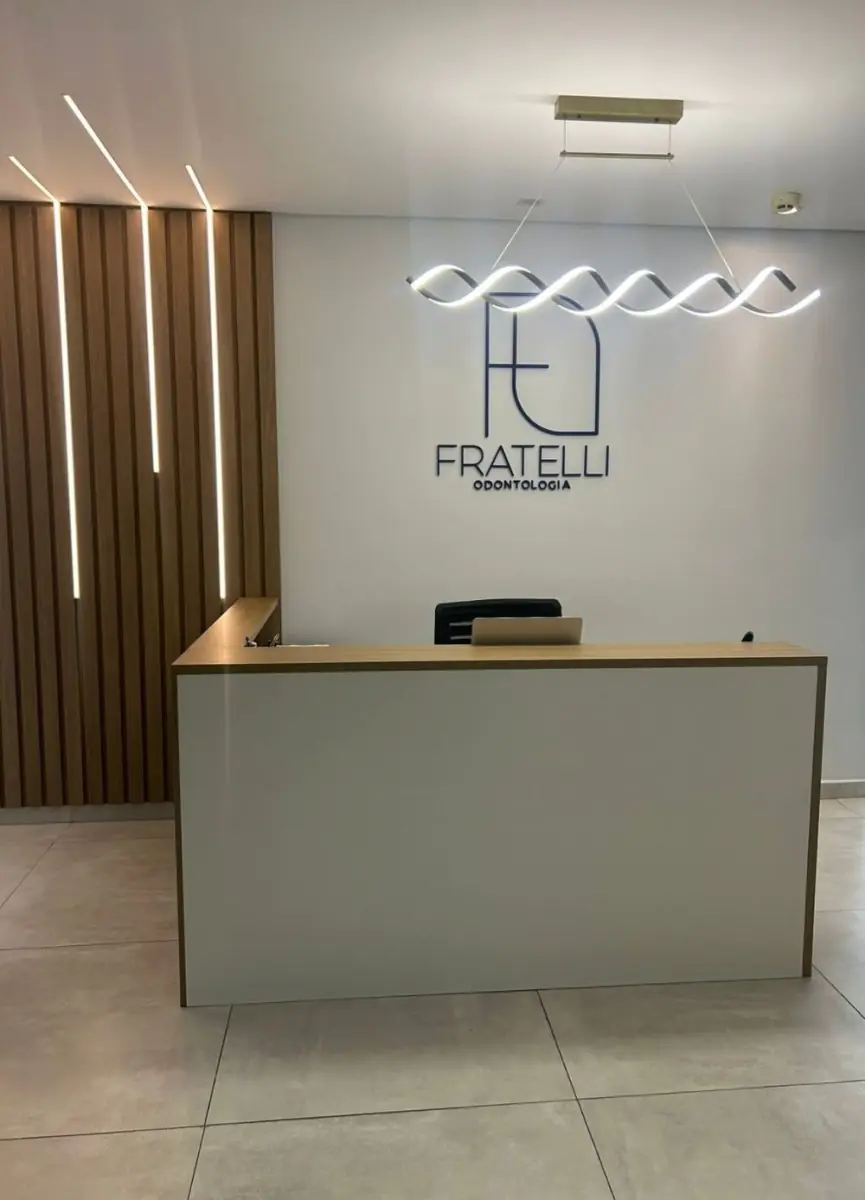 Empfangsbereich der Fratelli Odontologia Klinik mit modernem Design und Logo