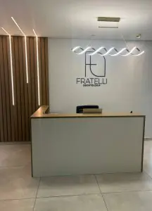 منطقة الاستقبال في عيادة Fratelli Odontologia بتصميم حديث وشعار