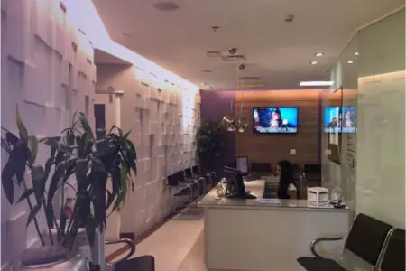 Área de recepción en la clínica ImplArt, diseño moderno con sillas y televisor