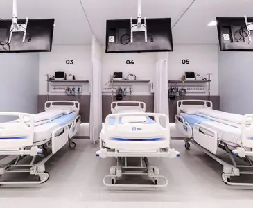 Sala de recuperación con camas modernas en la Clínica Dr. Bruno Gasperin
