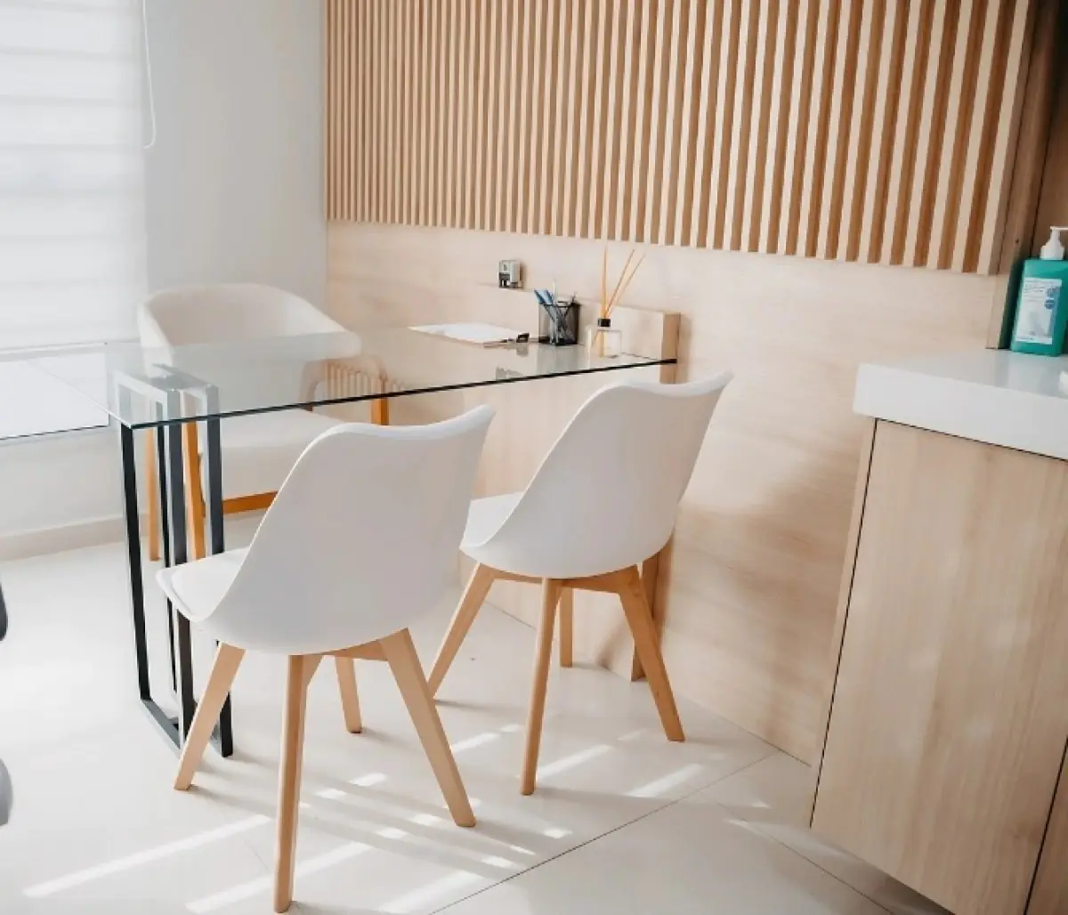 Consultation room at Camara Lopes clinic with modern glass desk and white chairs