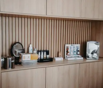 Productos cosméticos y espejos en estante de madera en la clínica Camara Lopes