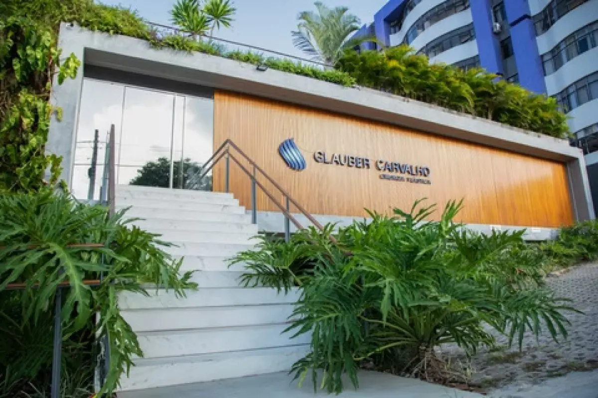 Modern clinic facade of Hospital Dia Glauber Carvalho with greenery and glass entrance