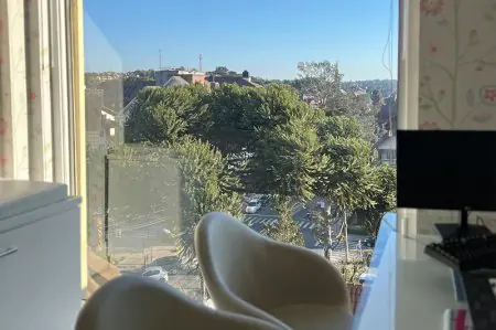 Sala de consulta en la clínica Dr. Eduardo Uebel con vista a la ciudad y espacio de trabajo moderno