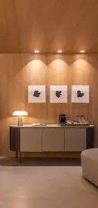 Área de espera moderna en la clínica Luciano Grisotto con estación de café y decoración minimalista