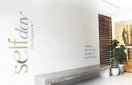 منطقة انتظار حديثة في Self Day Hospital مع مقعد حجري ونباتات داخلية