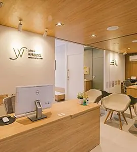 Área de recepción en Clínica W/Seidel con interior moderno de madera y asientos para pacientes