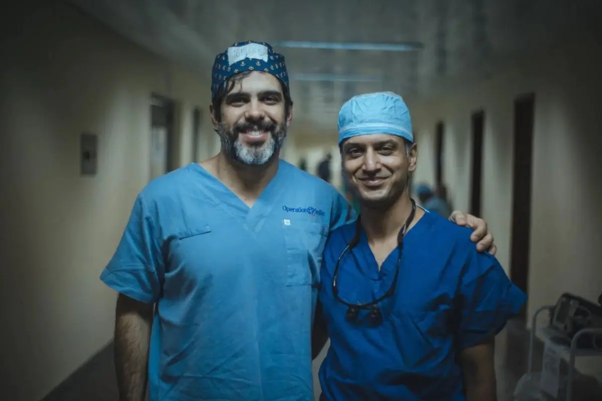 Surgeons in blue scrubs at Dr. Hugo Rodrigues clinic hallway