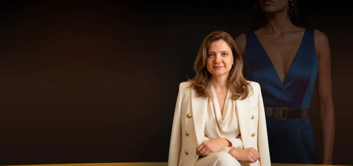 Anne Groth clinic staff member in formal attire against elegant backdrop