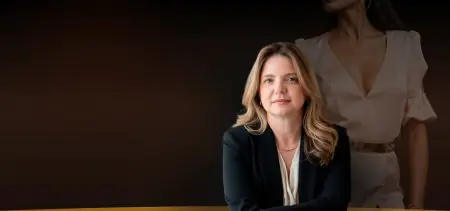 عضو فريق عيادة Anne Groth Show بملابس مهنية وخلفية تحمل شعار العيادة