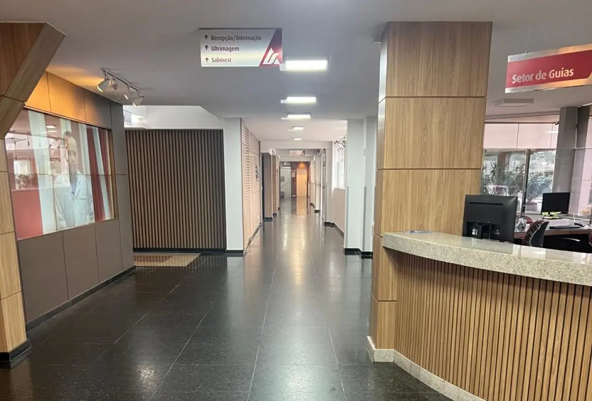 Reception area at Irmãos Leite plastic surgery clinic with modern wood panel design