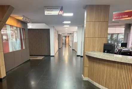 Área de recepción en la clínica de cirugía plástica Irmãos Leite con diseño moderno de madera