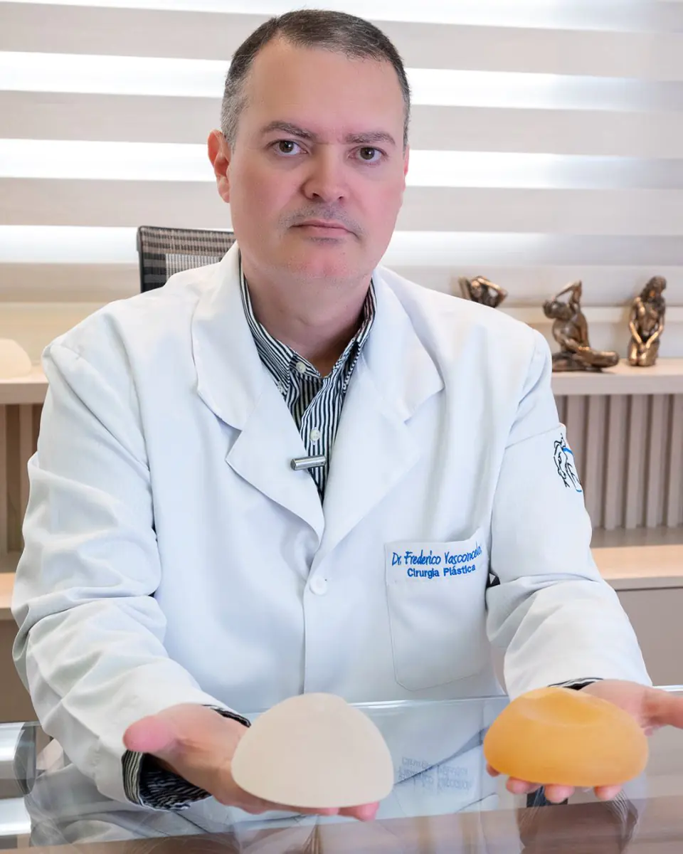 Plastic surgeon at Dr. Frederico Vasconcelos clinic showing breast implants