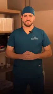جراح تجميل بالزي الطبي في غرفة استشارة عيادة Dr. Naby Gebrim