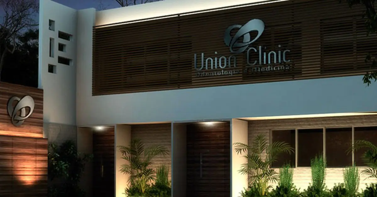 Moderne Fassade der Union Clinic mit beleuchtetem Eingang und Grünpflanzen