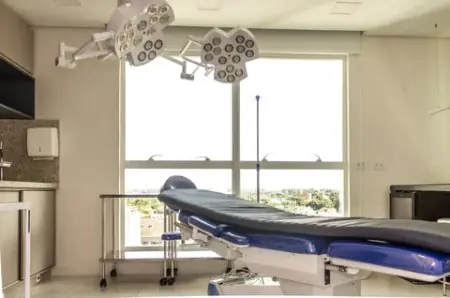 Quirófano moderno en Clínica França con luces quirúrgicas y cama para pacientes