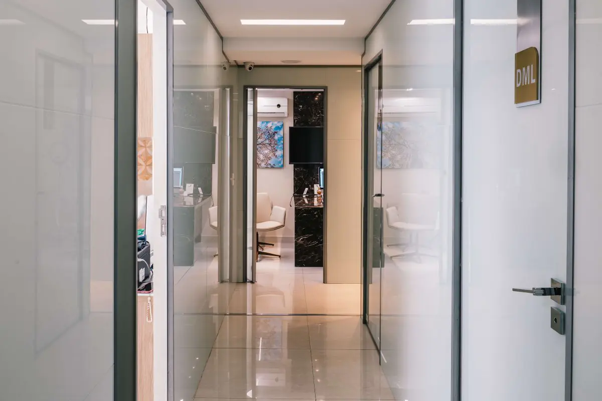 Modern clinic hallway at Costa Daher with glass doors and consultation rooms